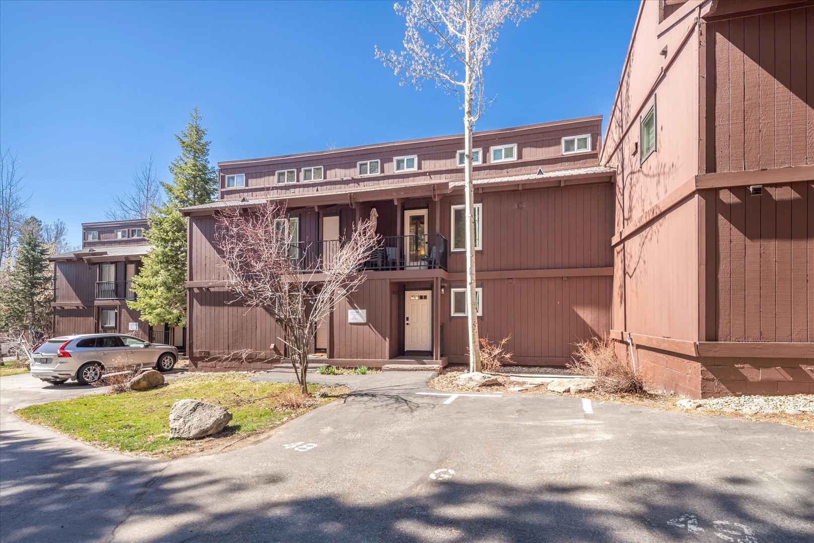 Modern wood-sided townhome complex with convenient parking and mountain lodge architecture in a peaceful residential setting.