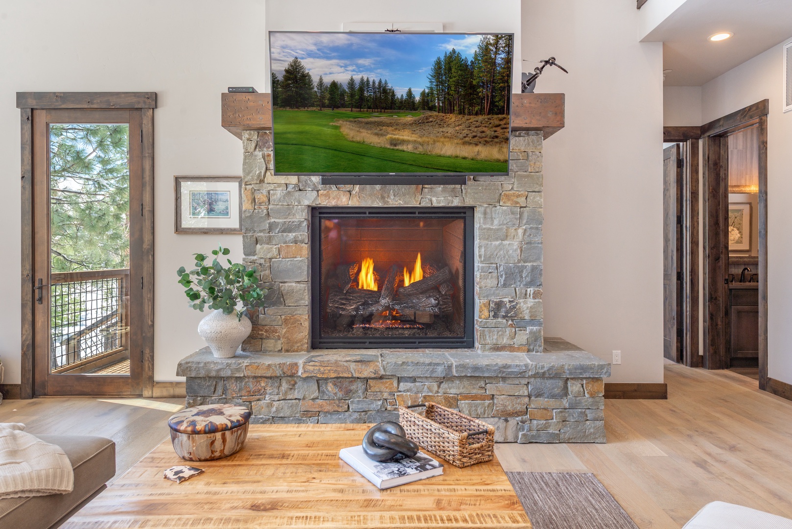 Cozy up by your crackling stone fireplace while watching the big screen TV in this warm, inviting living space.