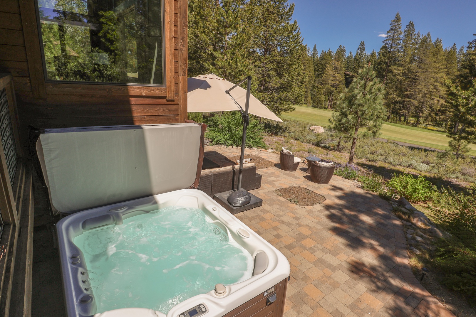 Soak in your private hot tub while gazing at the lush golf course framed by towering pines. Sunshine, fresh air, and mountain serenity—your perfect escape awaits on this spacious patio.