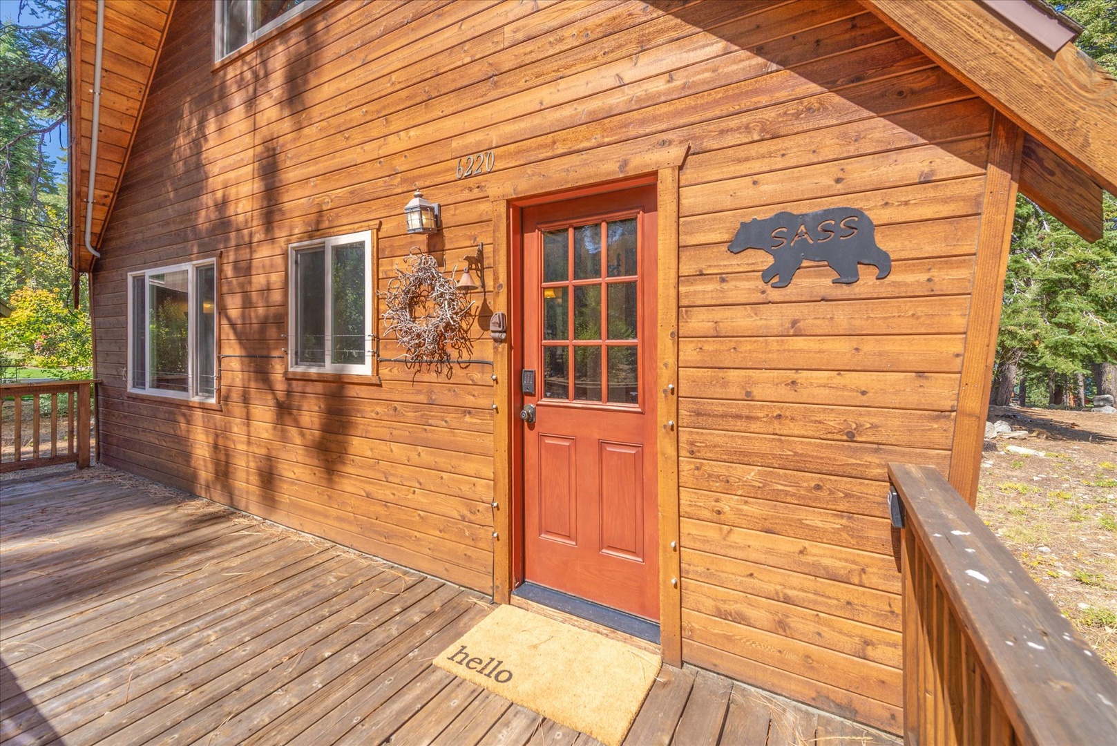 Wood-sided cabin entrance featuring a welcoming front door and deck where your mountain retreat begins.