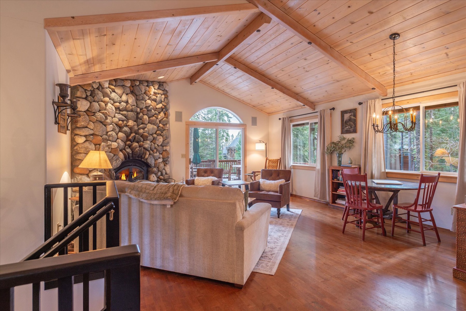 Curl up by the fireplace under the cathedral-ceiling retreat where rustic wood beams frame mountain views and cozy evenings await.