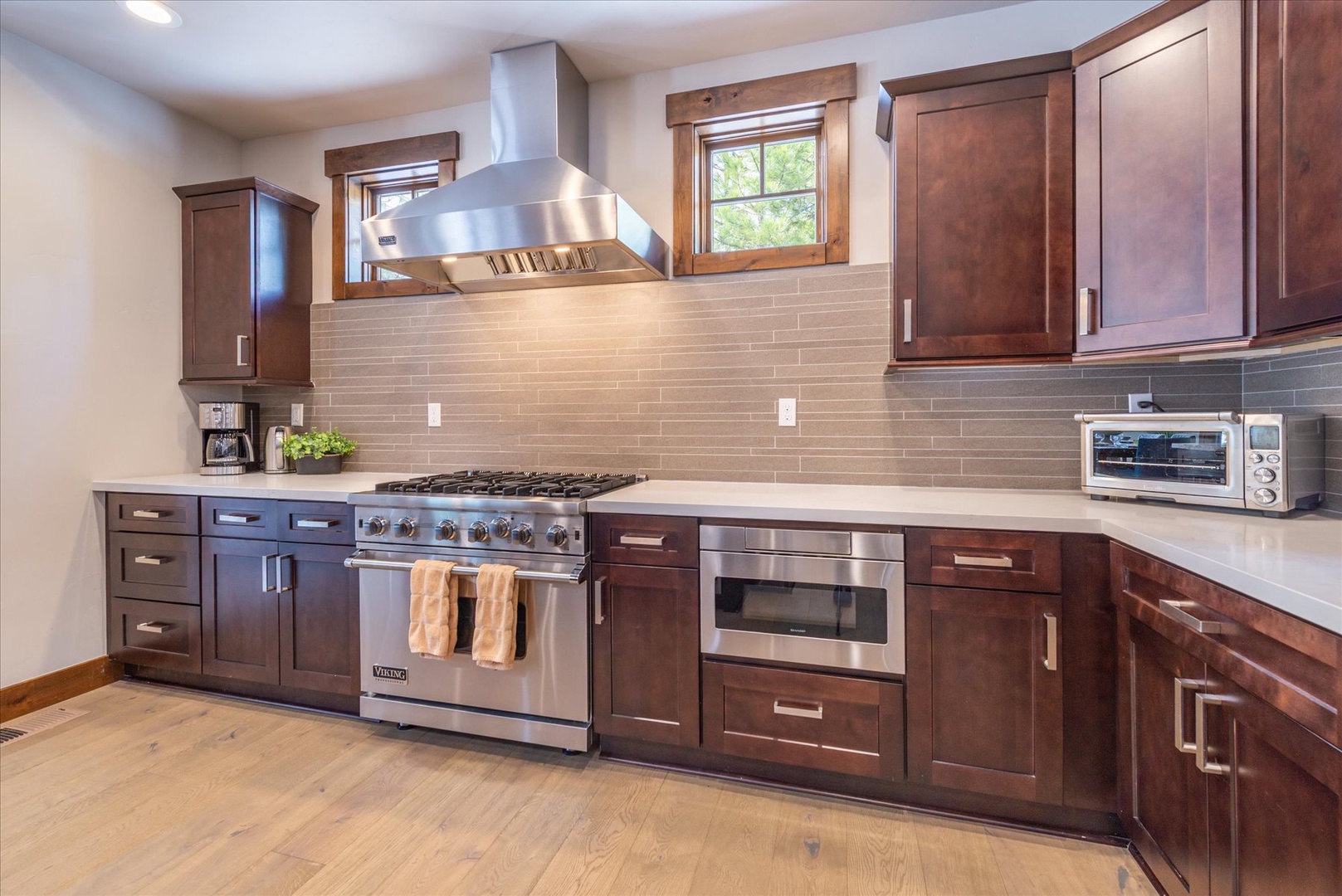 Cook your favorite meals in this beautifully appointed kitchen with rich wood cabinetry, professional-grade Viking stainless appliances, and sleek stone countertops.