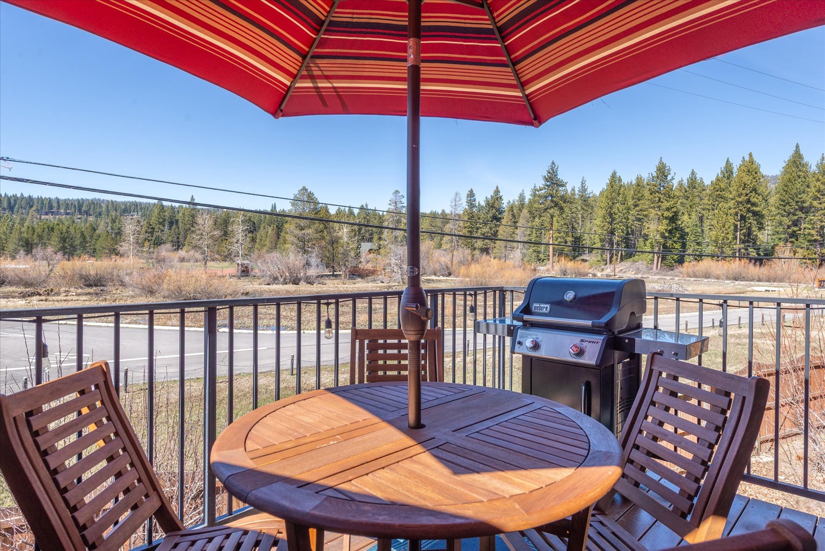 Your private outdoor dining terrace features a BBQ grill and shaded table where you can enjoy meals with meadow views.