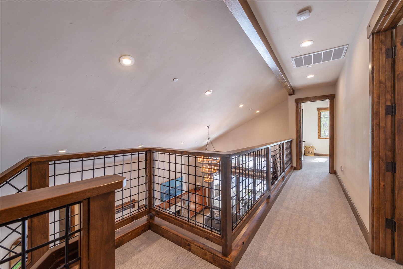 This upper-level hallway connects your private spaces with warm wood details and contemporary railings.