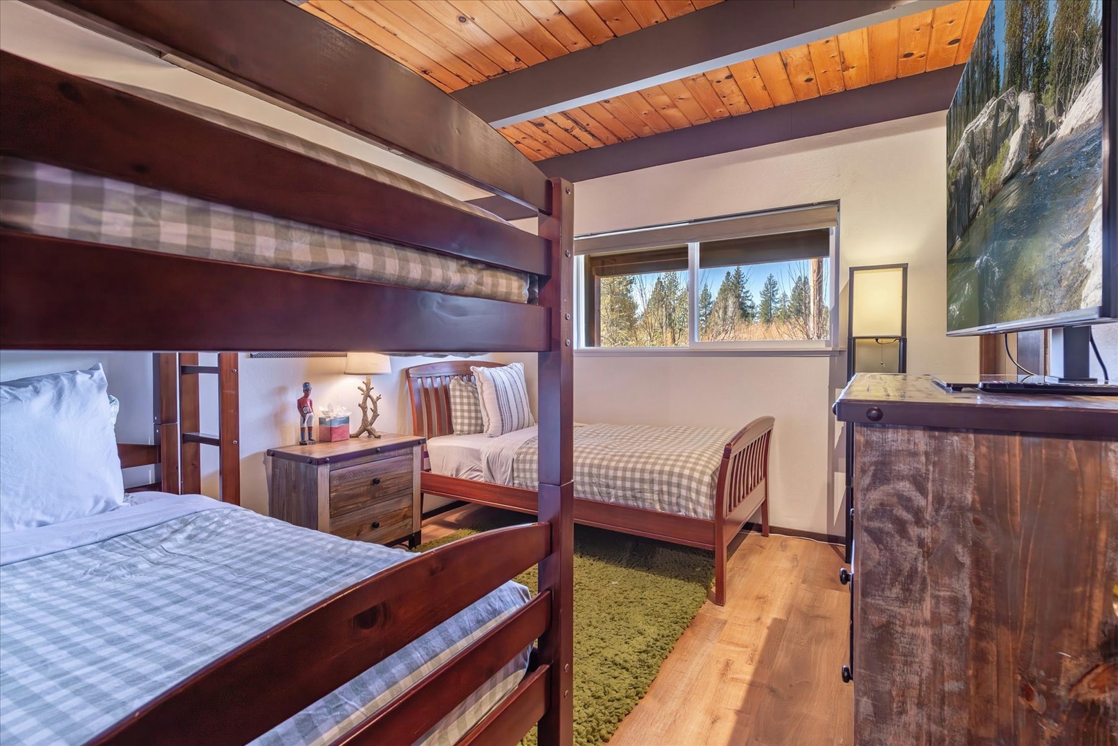 Your cozy bunk room features warm wood finishes and forest views, perfect for restful nights after adventure-filled days.