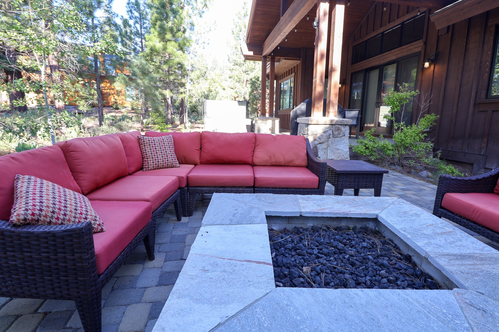 Unwind around your private outdoor fire pit on plush coral seating, surrounded by towering pines and mountain tranquility—perfect for crisp evenings under the stars.