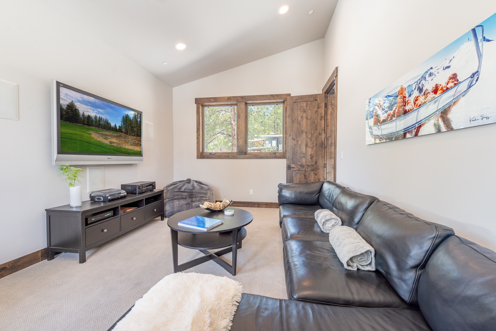 Sink into plush leather seating while you enjoy mountain views through charming wooden shutters in your bright, modern living space.