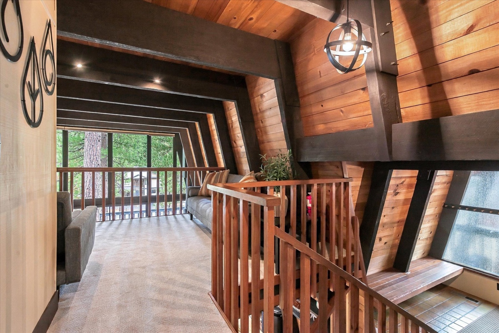 Step into your charming A-frame retreat where warm wood beams and soaring ceilings create an inviting mountain getaway. The open loft area leads to a peaceful balcony overlooking tall pines—your perfect spot to unwind.