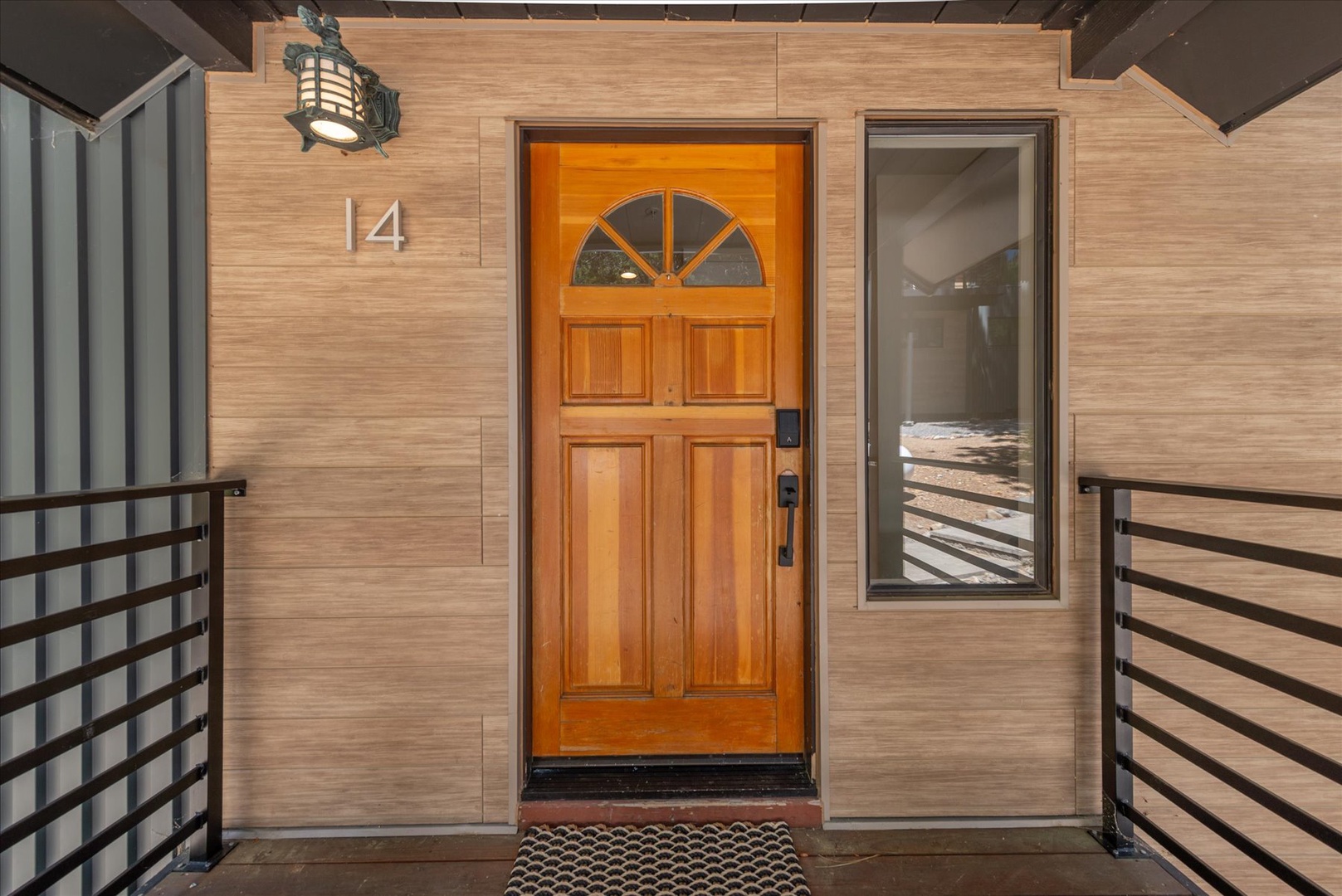 The property's welcoming front entrance at unit 14 features warm wood accents and modern architectural details, marking your arrival at this thoughtfully designed vacation retreat.