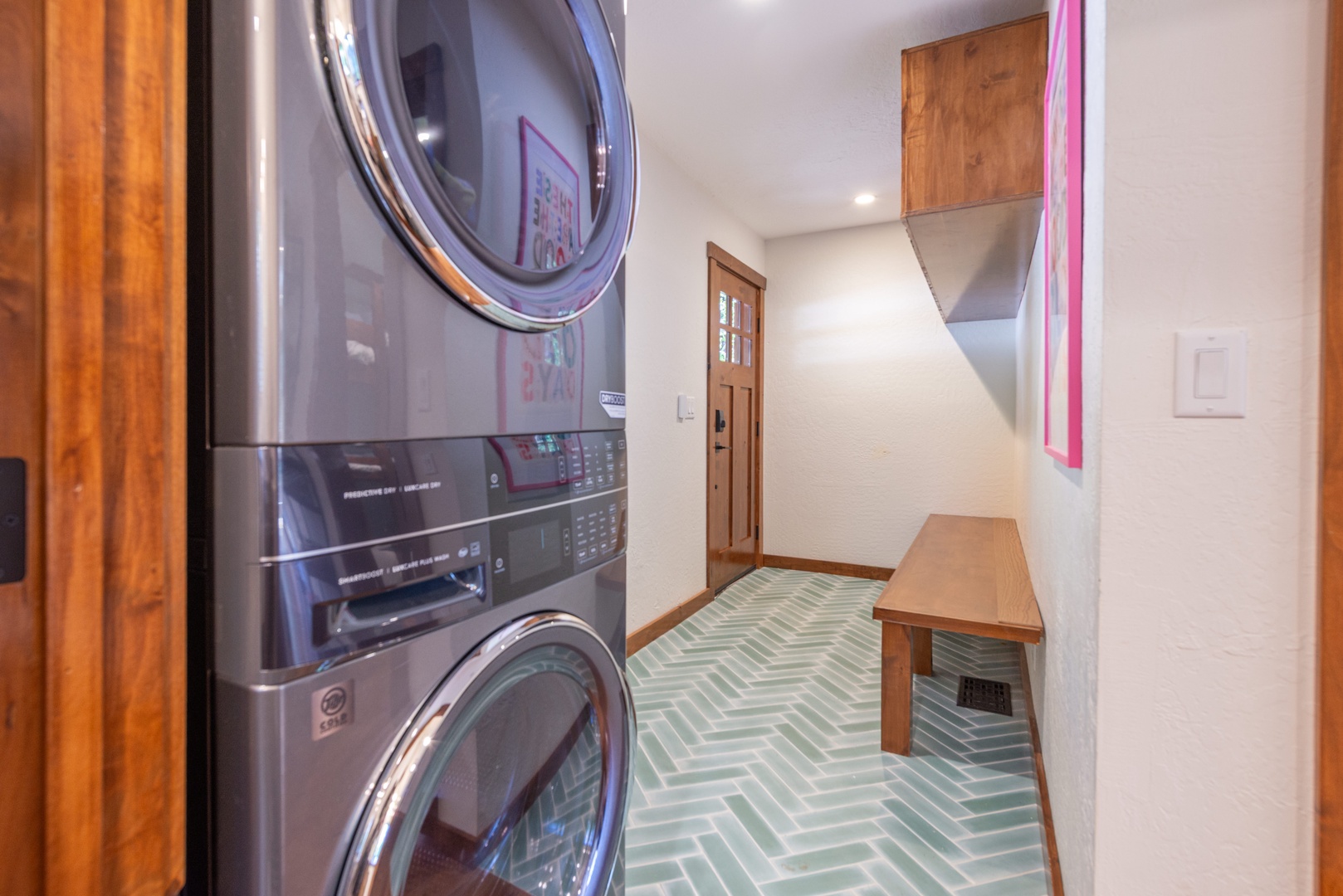 Step into your convenient laundry space, where modern appliances meet charming herringbone tile floors and warm wood accents—making chores feel a little less like work.