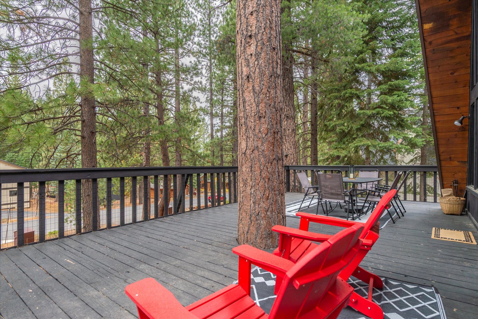 Step onto your private deck and breathe in the crisp mountain air, surrounded by towering pines. Unwind in these red Adirondack chairs, listen to nature, and disconnect from it all.
