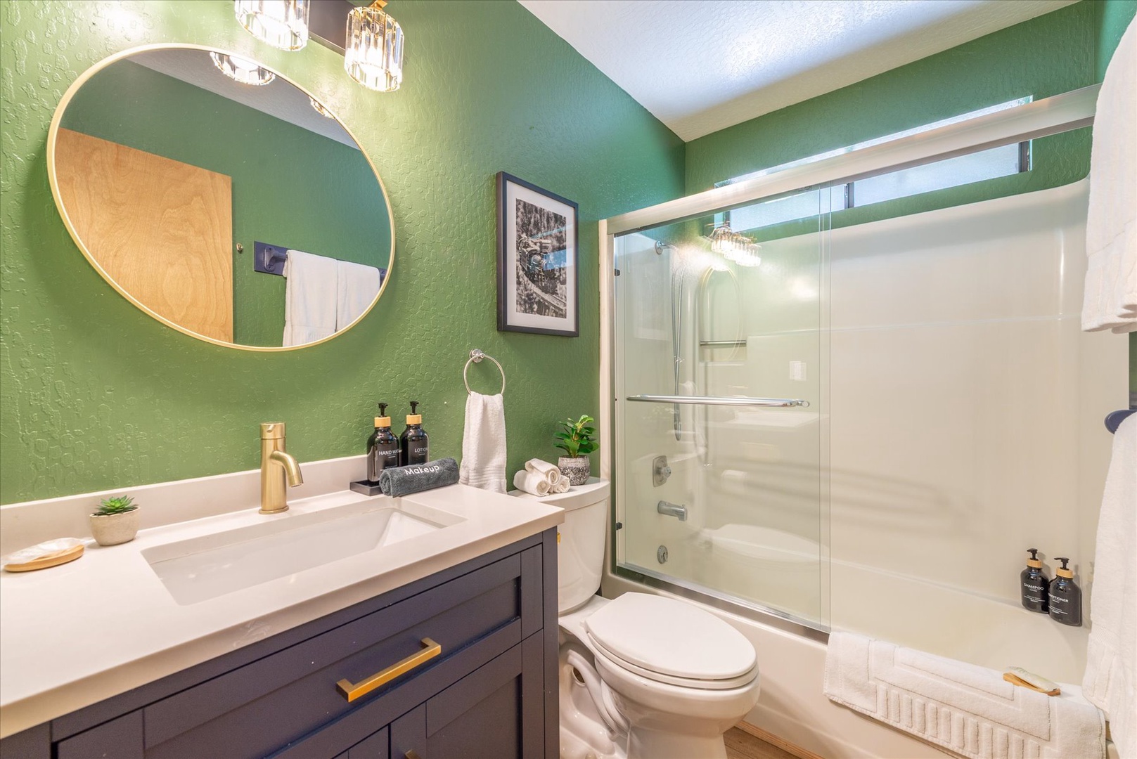 Refresh in your stylish bathroom featuring modern amenities, spa-like touches, and elegant green accent walls that create a calming retreat.