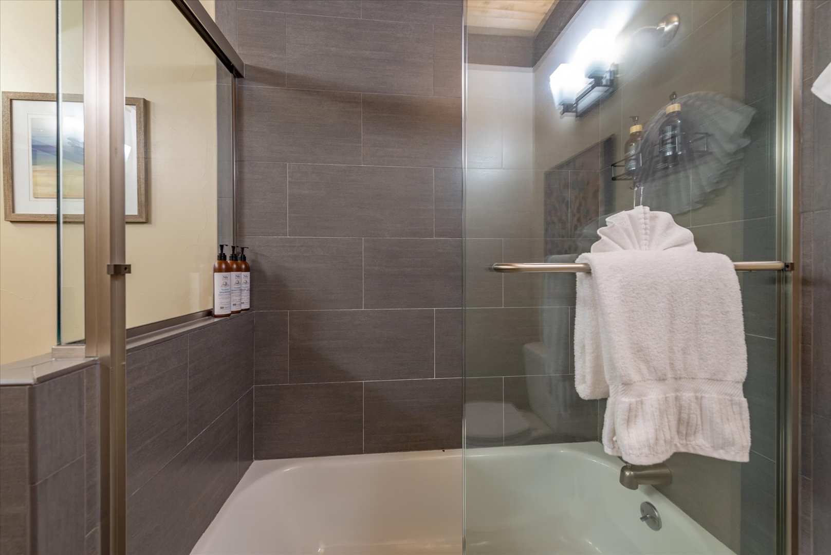 Step into your private spa-like bathroom with sleek glass shower, luxurious towels, and premium amenities waiting for your perfect relaxation.