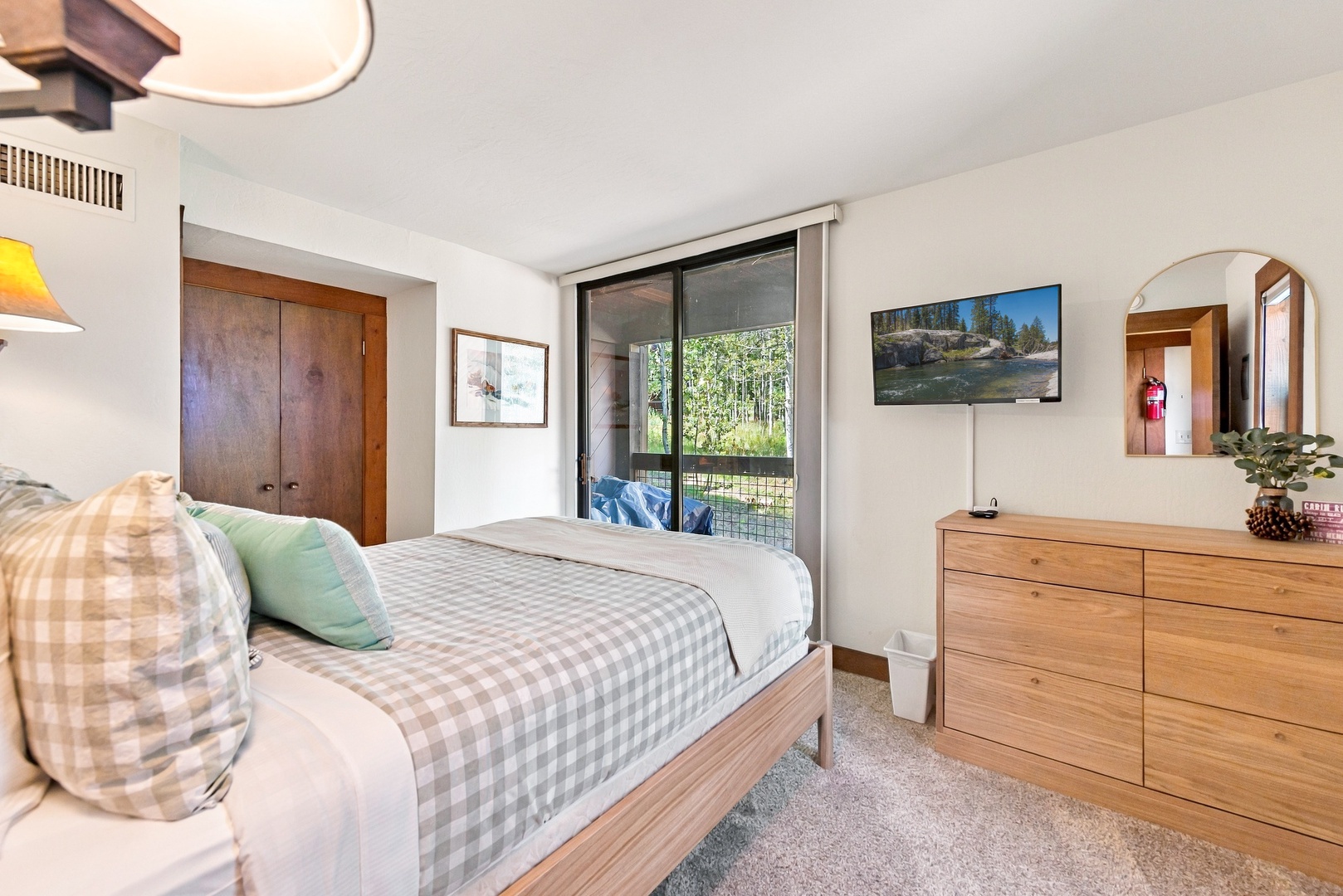 Unwind in this peaceful bedroom with soft linens, warm wood tones, and a sliding door that opens to your private outdoor space. Natural light fills the room, inviting you to relax and recharge.