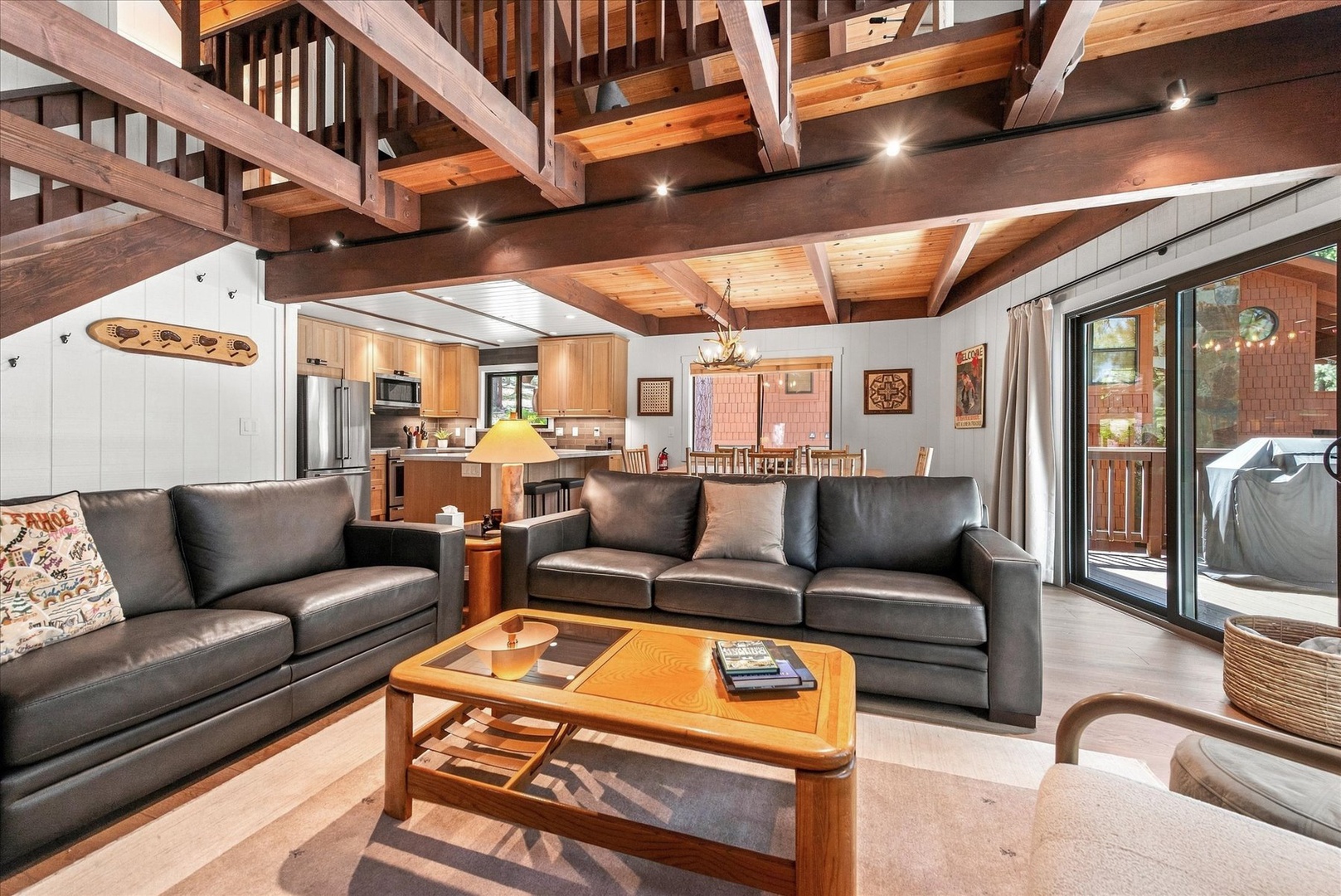 Relax under soaring wood beams in your open-concept living space, where plush leather sofas and warm tones create the perfect retreat after a day of adventure.
