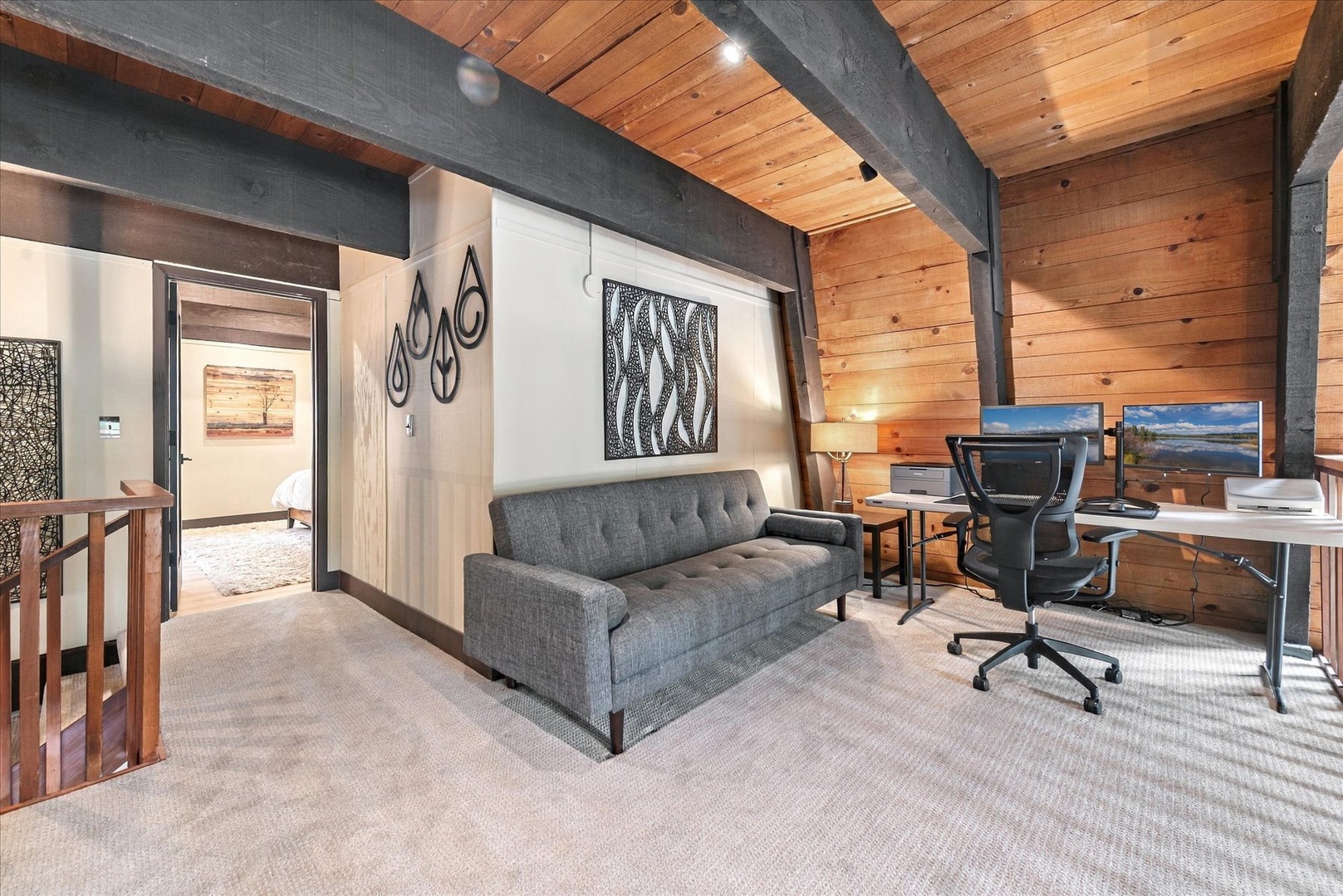 Your upstairs loft blends rustic warmth with modern comfort—exposed beams, natural wood, a cozy sofa, and a spacious workspace where you can catch up on emails or simply unwind.