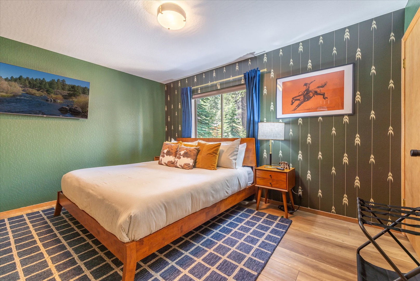 Unwind in your stylish bedroom with unique arrow wallpaper, cozy mid-century furnishings, and peaceful forest views from your window.