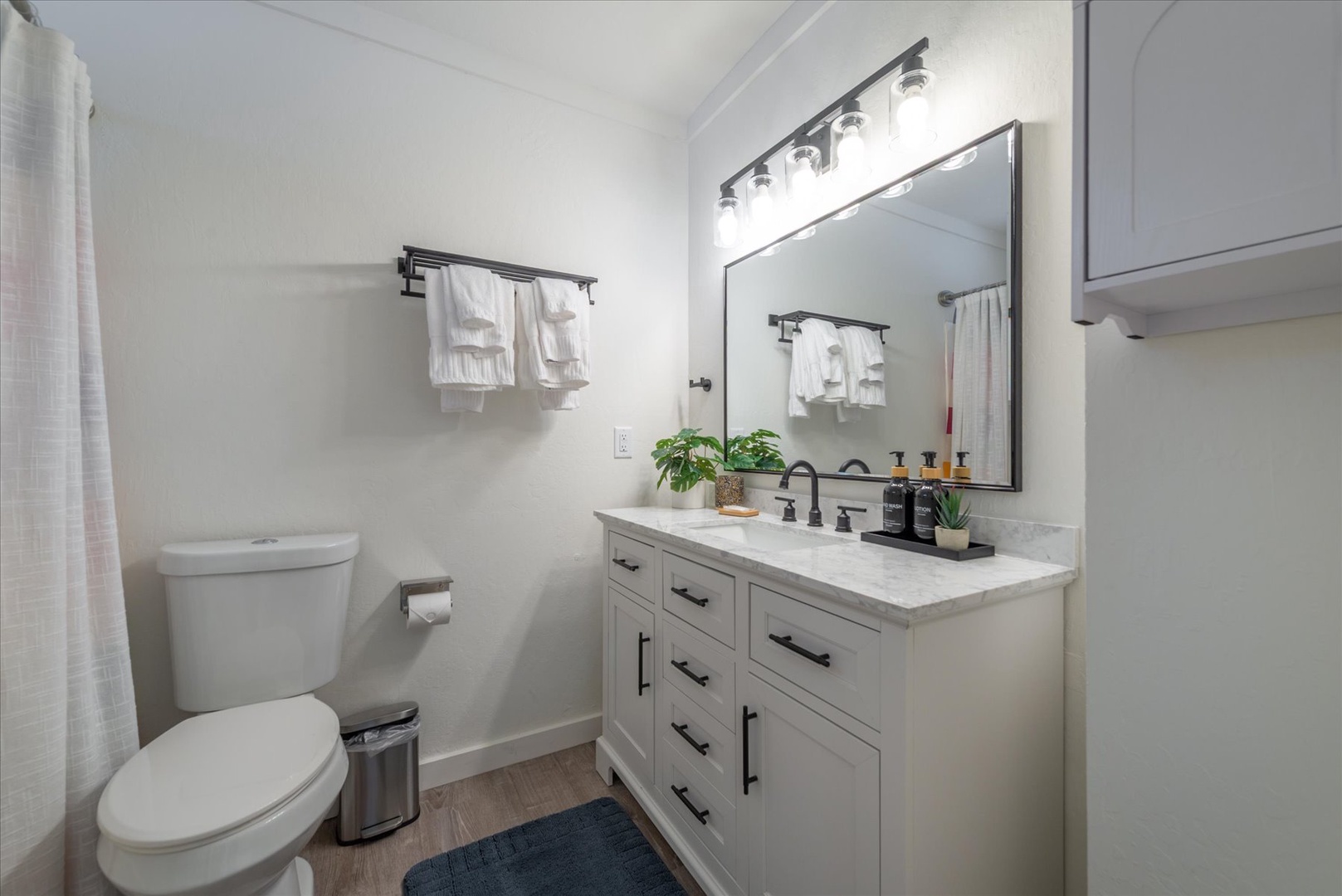 Freshen up in your private, modern bathroom with plush towels, stylish fixtures, and thoughtful touches like plants and premium toiletries ready for your arrival.