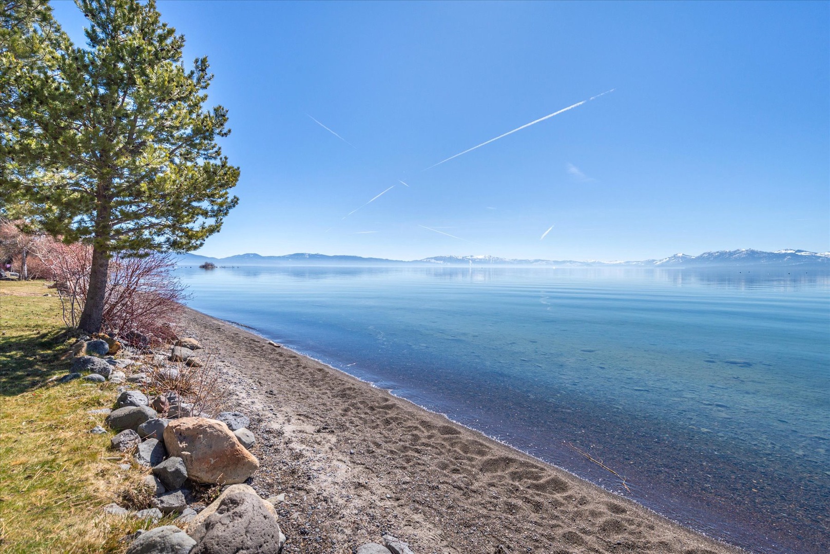 Enjoy pristine lakefront with sandy shoreline and mountain backdrop creates a serene natural setting.