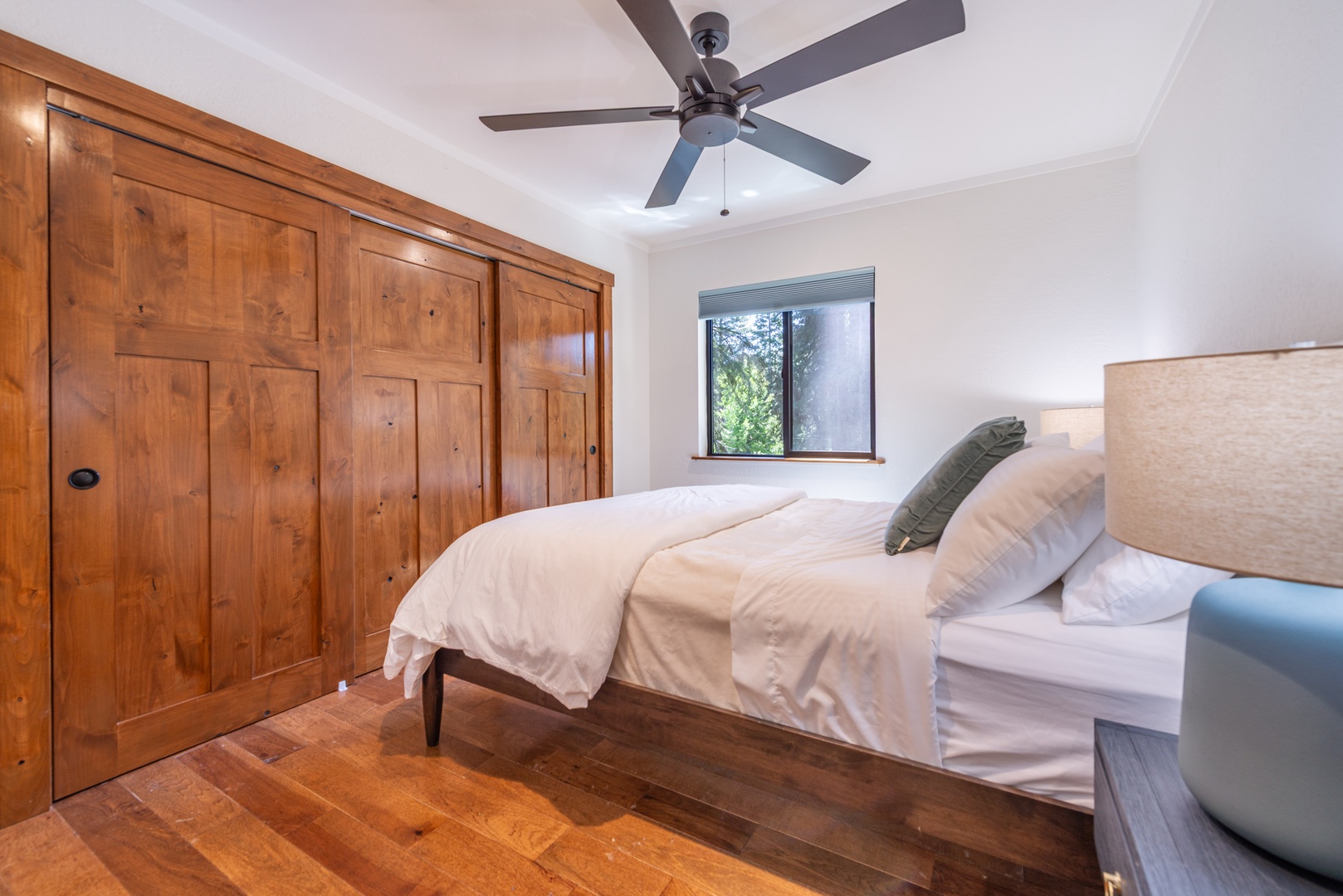 Drift off to sleep in the upstairs queen bed with plush bedding while surrounded by warm wooden finishes.