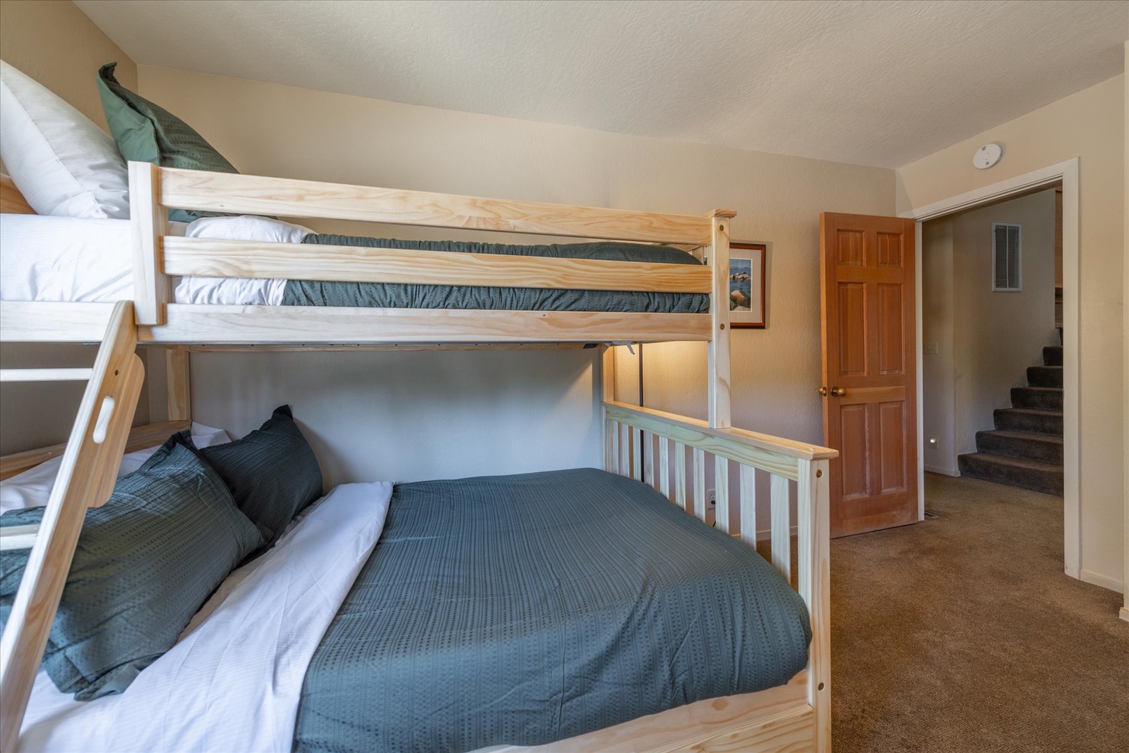 Spacious bedroom with sturdy bunk beds dressed in soft linens, perfect for families. Your group will rest easy in this comfortable, light-filled space with plenty of room to move around.