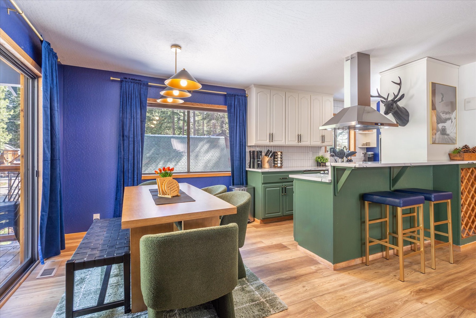 Your stylish open kitchen features bold green island, dining nook, and vibrant blue accents—perfect for cooking memorable meals together.
