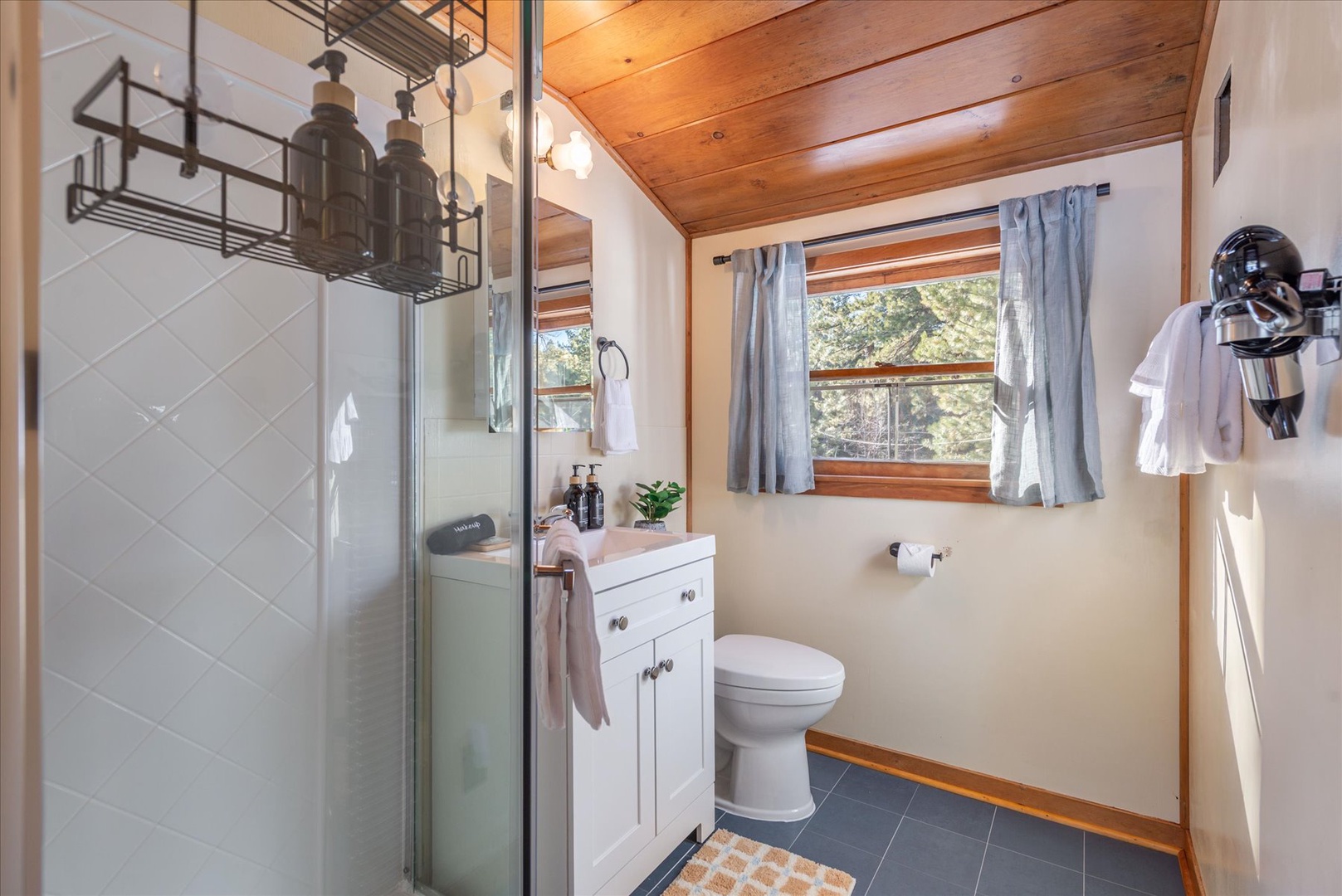 This quaint upstairs bathroom with updated flooring makes you feel right at home in the mountains.