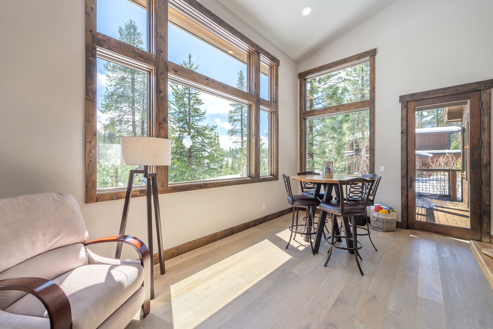 Relax in your bright dining nook with stunning forest views through floor-to-ceiling windows, perfect for morning coffee or intimate meals.