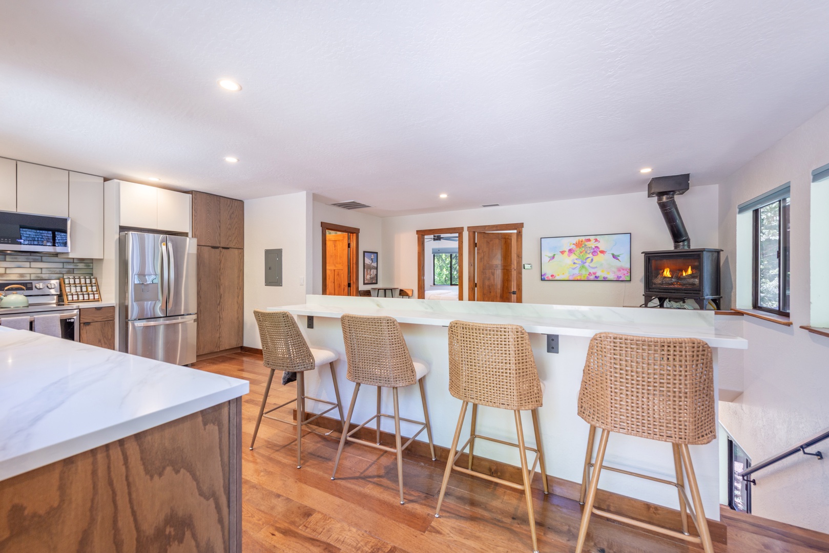 Gather around this welcoming kitchen bar, where natural textures and warm wood tones invite you to share meals and make memories. The cozy fireplace adds a mountain lodge charm to your vacation retreat.