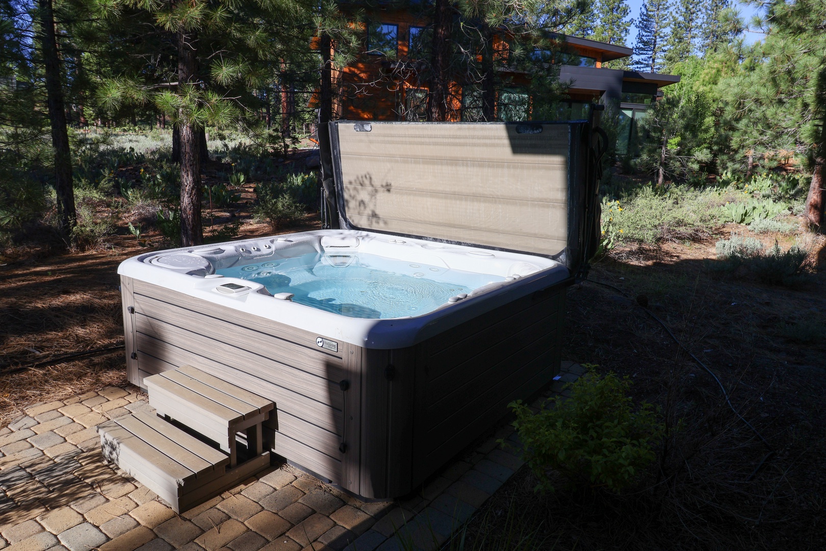 Unwind in your private hot tub surrounded by towering pines—perfect for soaking under the stars after a day of adventure.