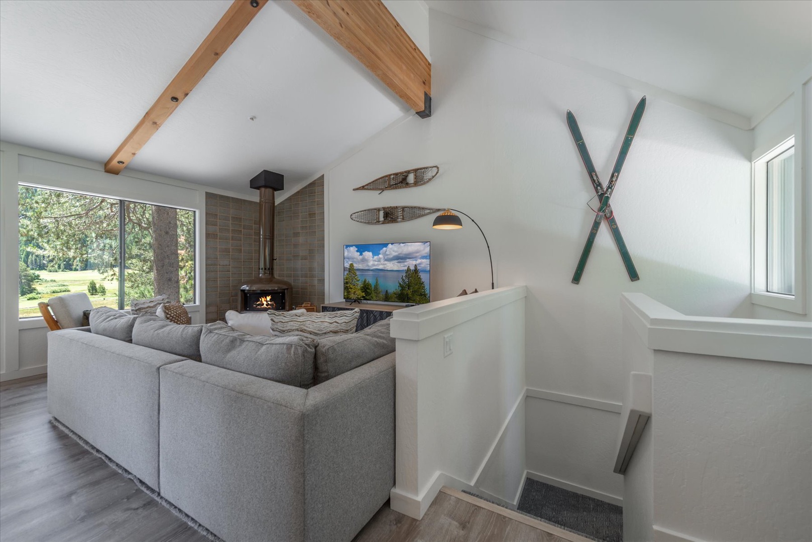 Unwind in your spacious living area featuring vaulted ceilings, cozy fireplace, and plush seating perfect for gathering with loved ones after a day of adventure.