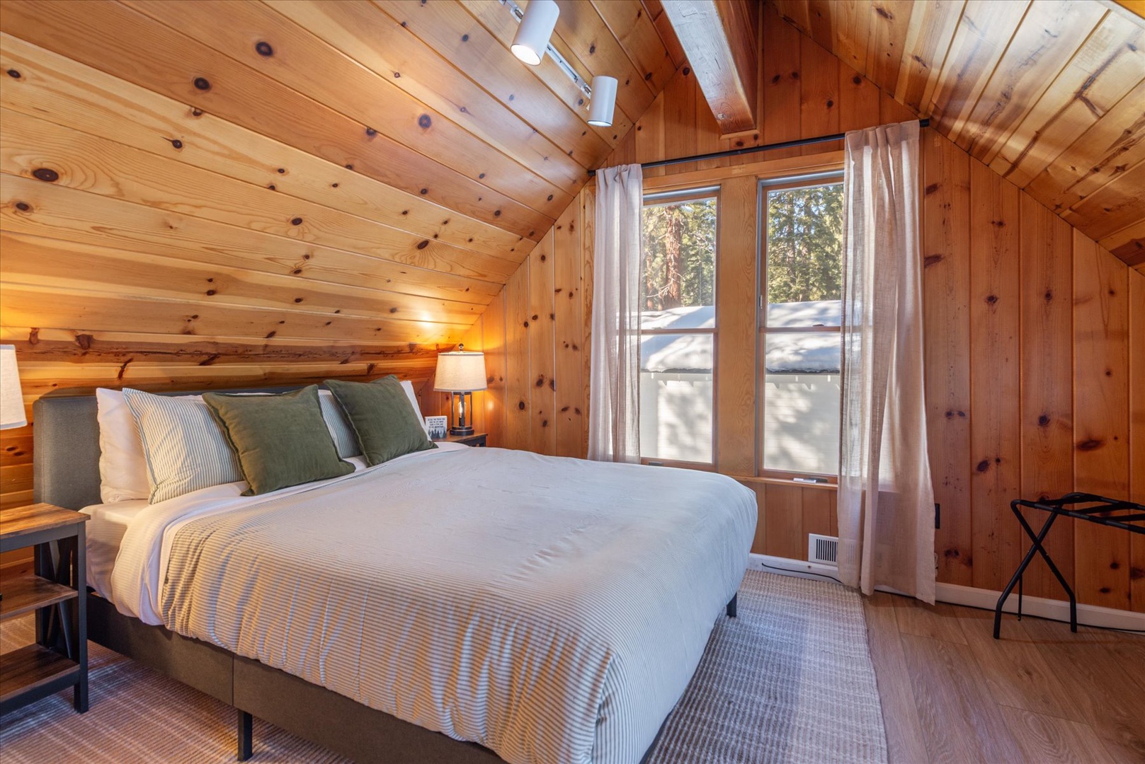 You're sure to get a good nights rest in this queen sized bed with plush linens and streaming natural light through nearby windows.