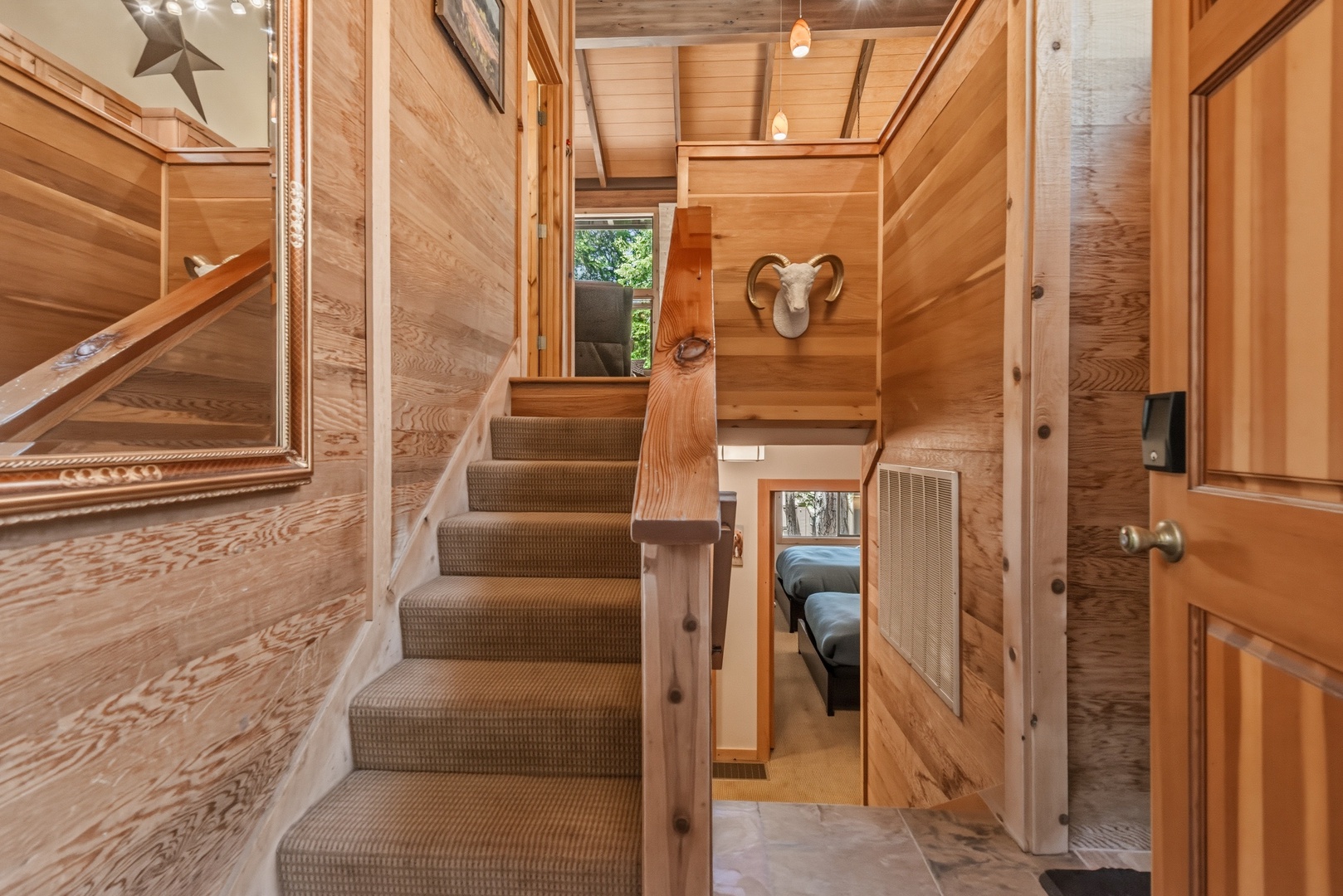 Step into your cozy loft retreat where warm wood tones create an inviting mountain escape. The clever two-story layout maximizes space beautifully, with a charming staircase leading to your private sleeping area above.