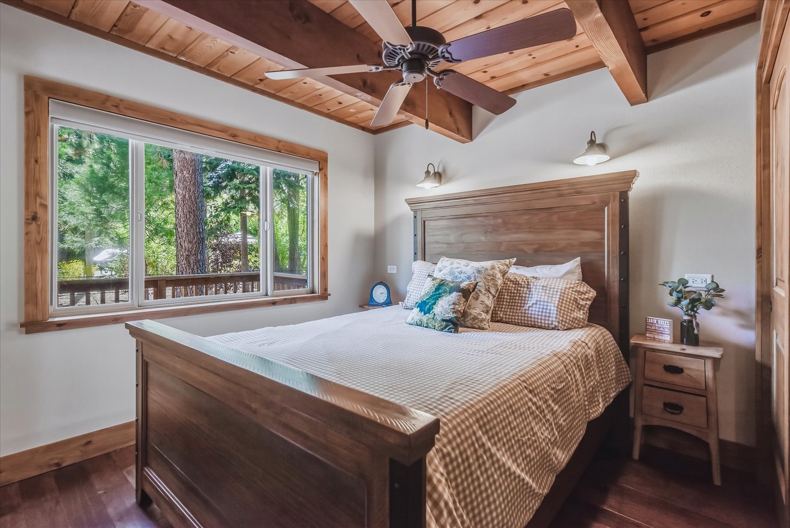 Drift off in your cozy downstairs bedroom, where soft natural light pours through large windows framing peaceful forest views.