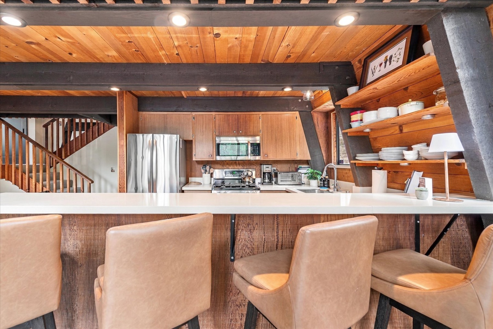 Gather around the sleek breakfast bar where warm wood tones and modern finishes create your perfect mountain retreat kitchen. Everything you need is at your fingertips for easy meal prep and memorable conversations.