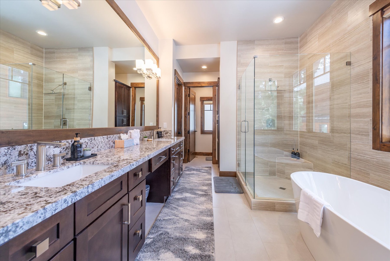Indulge in your private spa-like retreat with double sinks, ample counter space, soaking tub, spacious shower, and elegant granite finishes for ultimate relaxation.