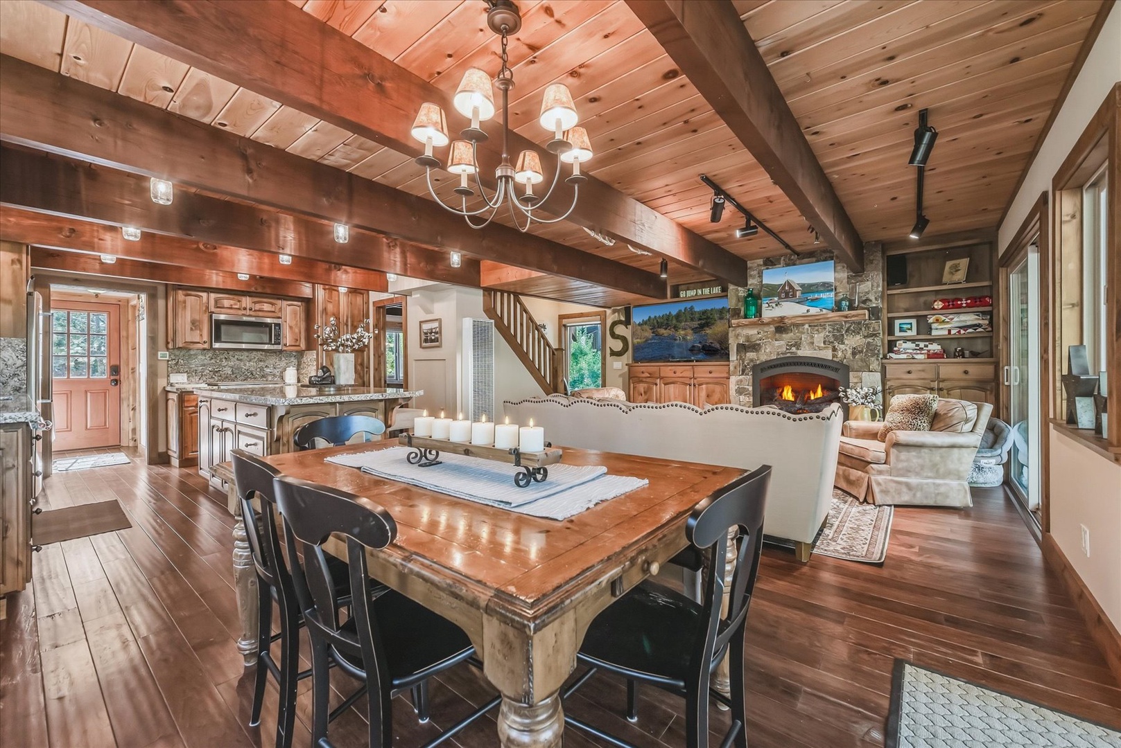 Step into your welcoming open-concept cabin where rustic wood beams, rich hardwood floors, and a crackling stone fireplace create the perfect mountain retreat for gathering with loved ones.