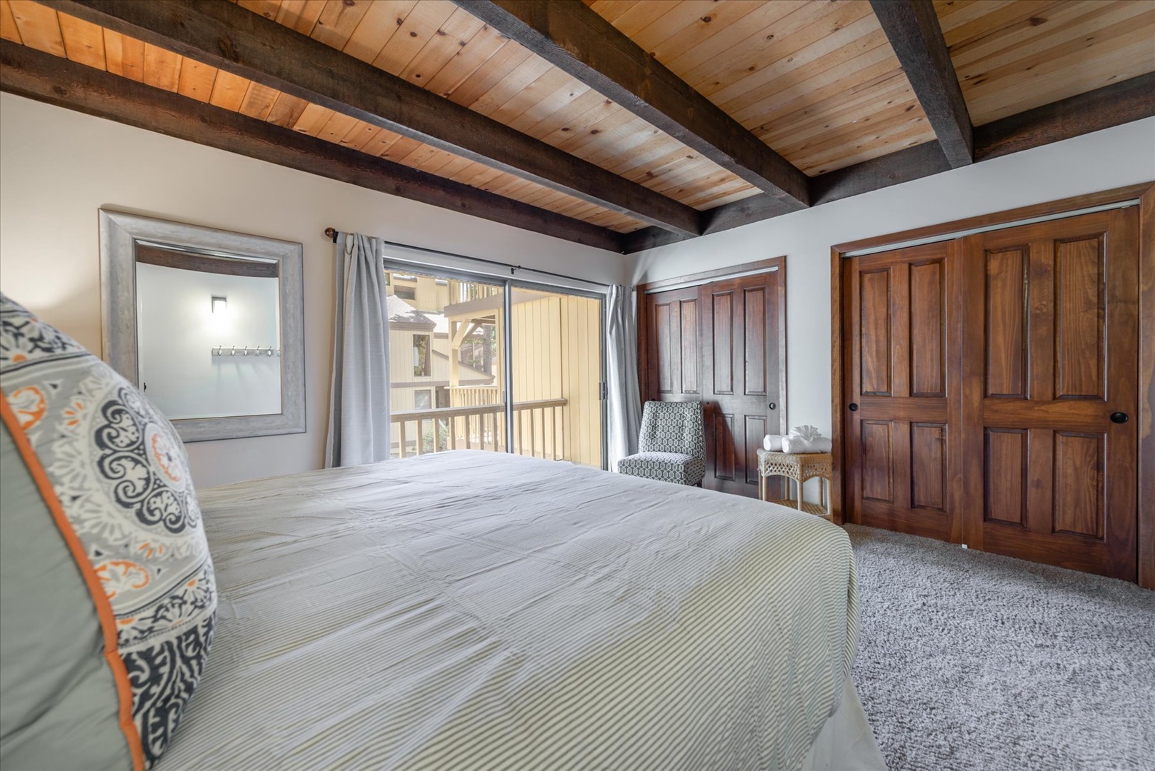Rest peacefully under striking exposed beams in your cozy bedroom, where rustic charm meets modern comfort for the perfect mountain retreat.