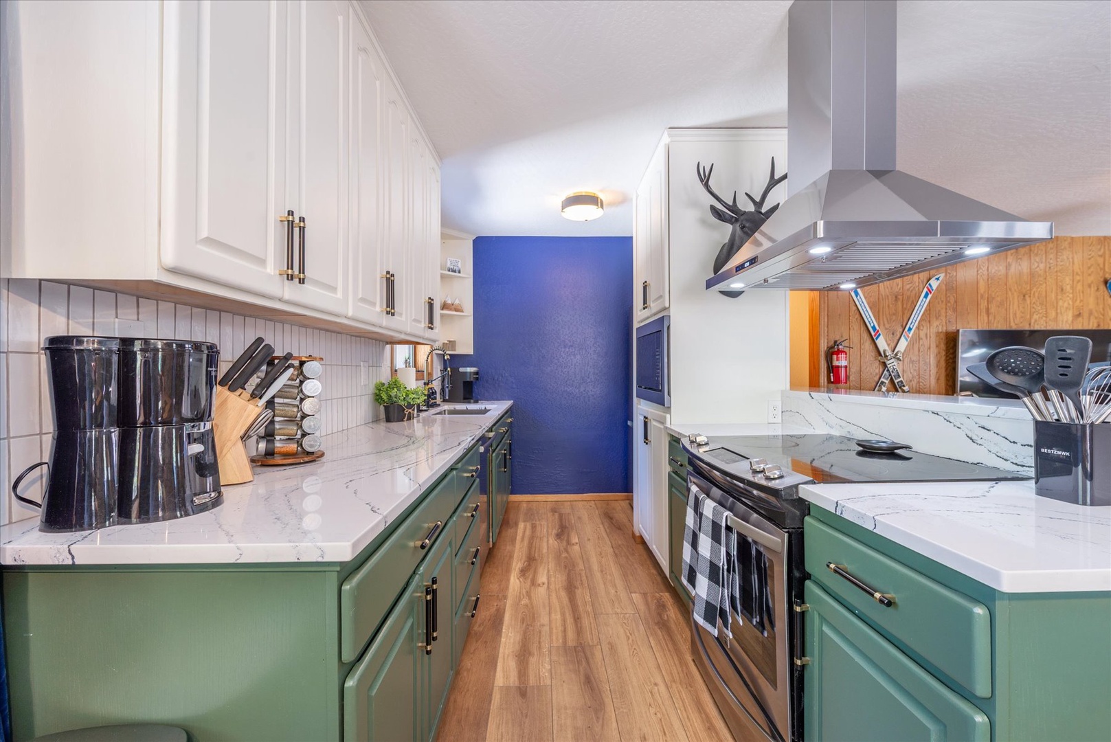 Cook your favorite meals in this modern galley kitchen with marble counters, professional appliances, and mountain charm decor.