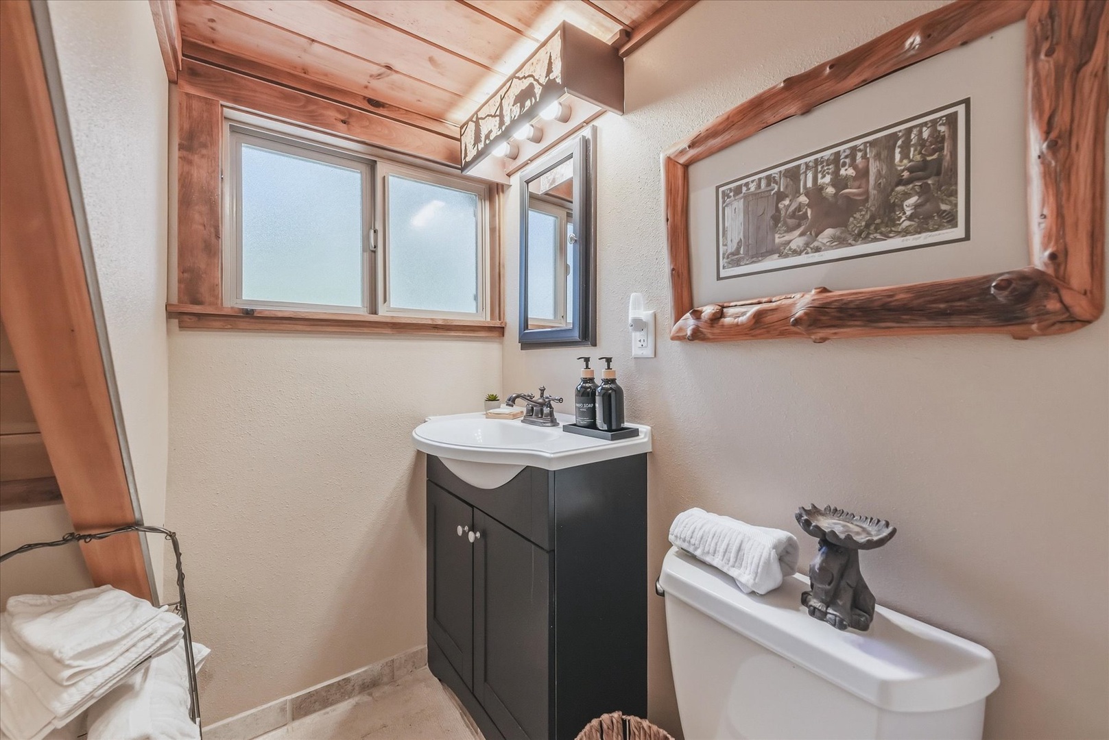 Step into your cozy bathroom where rustic wood beams meet modern comfort, complete with fresh towels and thoughtful touches to make you feel right at home.