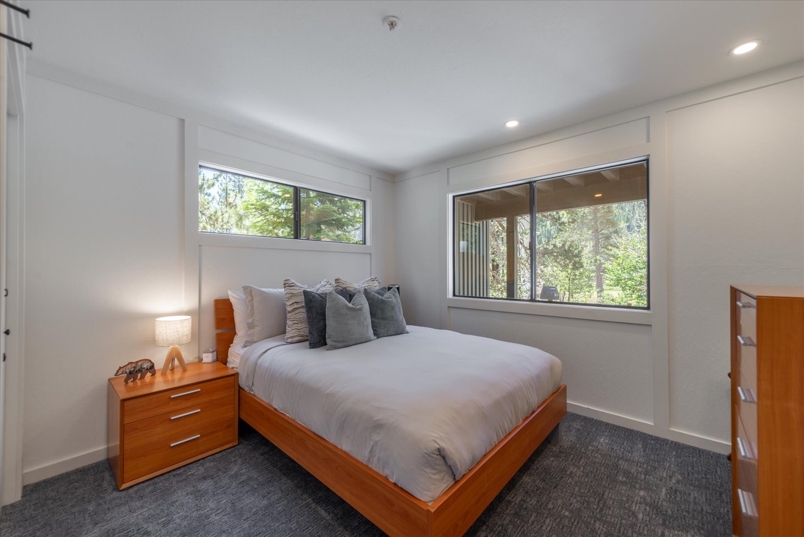 Sink into plush linens and wake to leafy views through large windows. Your private retreat features warm wood furnishings, soft lighting, and peaceful garden vistas—perfect for restorative sleep.