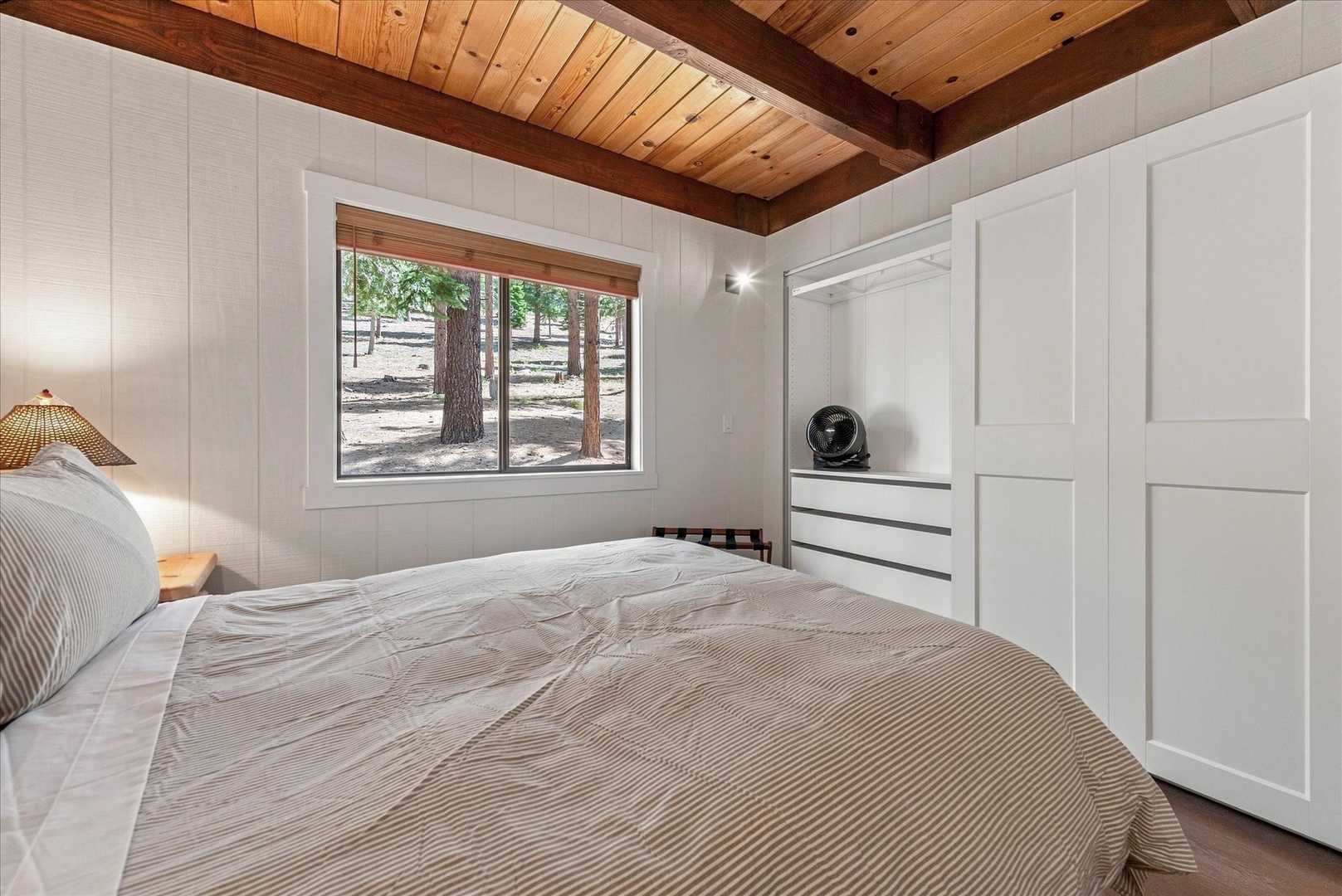 Sink into your cozy bed and wake to peaceful forest views framed by the window.