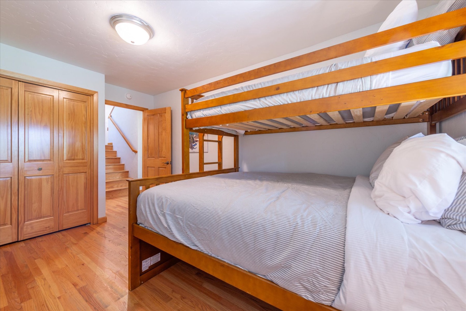 Sleep soundly in this clever bunk setup, featuring twin over full beds dressed in soft linens and plenty of space to spread out beneath warm wood beams and natural light.