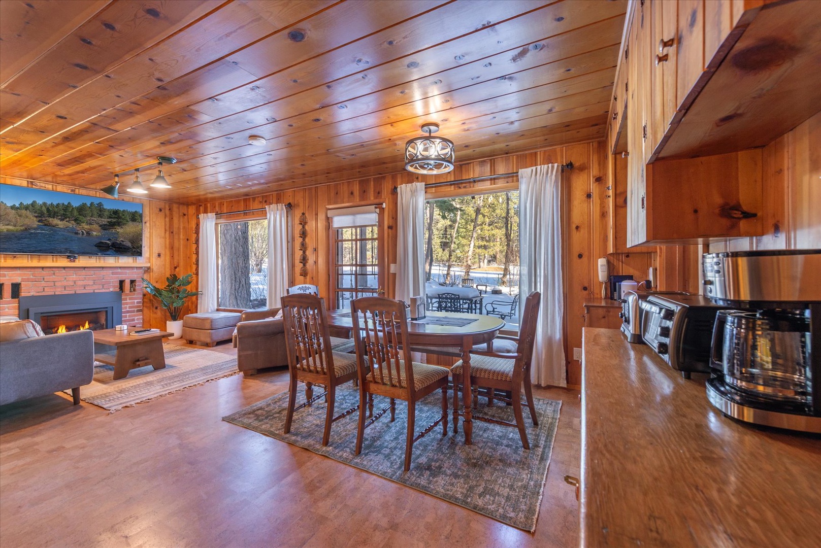 Step into your cozy cabin retreat where warm wood surrounds you, a crackling fireplace awaits, and forest views inspire peaceful moments.