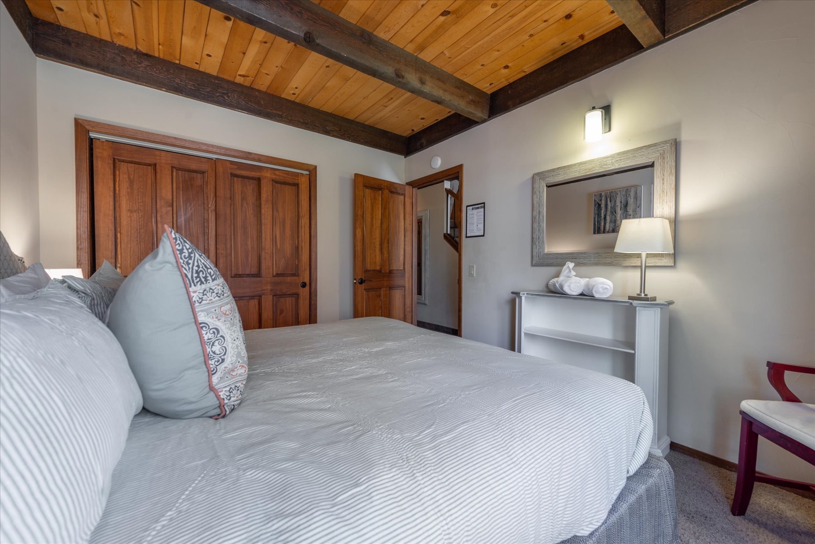 Sink into crisp linens beneath rustic wood beams in your cozy retreat, where thoughtful touches create the perfect mountain getaway.