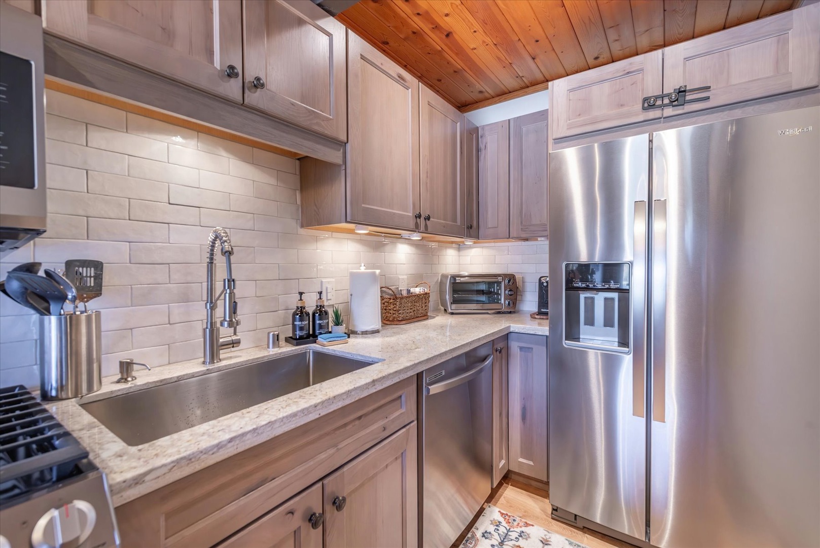 Your fully equipped kitchen features stainless steel appliances and warm wood cabinetry, perfect for preparing memorable meals during your stay.