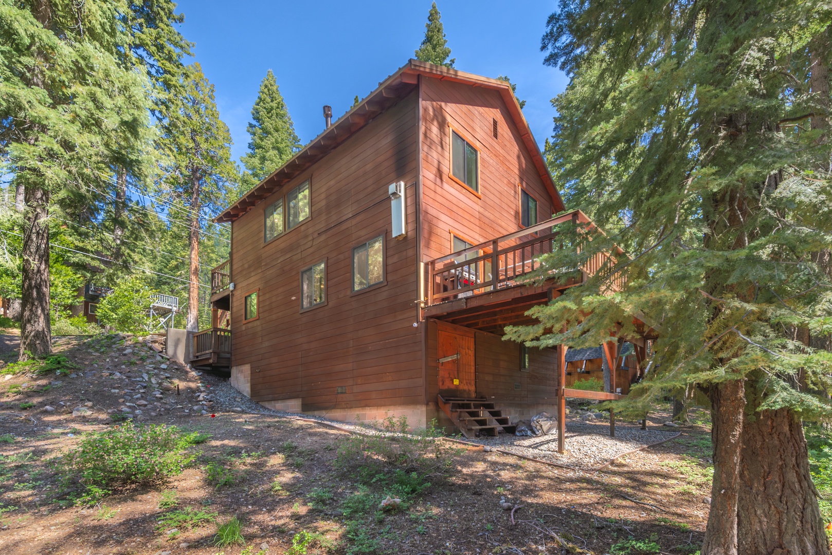 A welcoming mountain chalet nestled among towering pines, featuring warm wood siding and a private balcony where the scent of fresh alpine air greets you each morning.