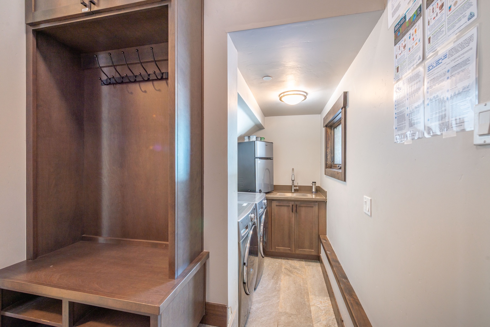 Your mudroom features built-in storage cubbies and hooks, flowing seamlessly into a convenient laundry area with full-sized appliances.