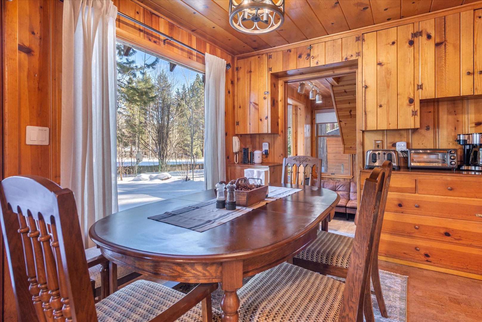 The wooden dining table provides ample seating for friends and family to gather around for a home cooked meal.