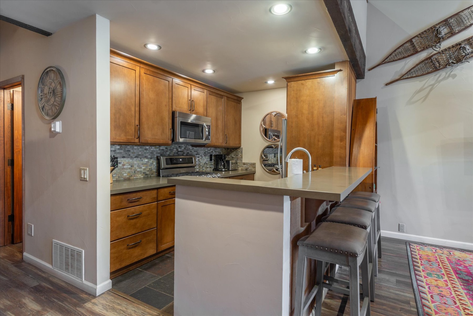 Your modern kitchen features warm wood cabinets, sleek appliances, and a breakfast bar perfect for morning coffee.